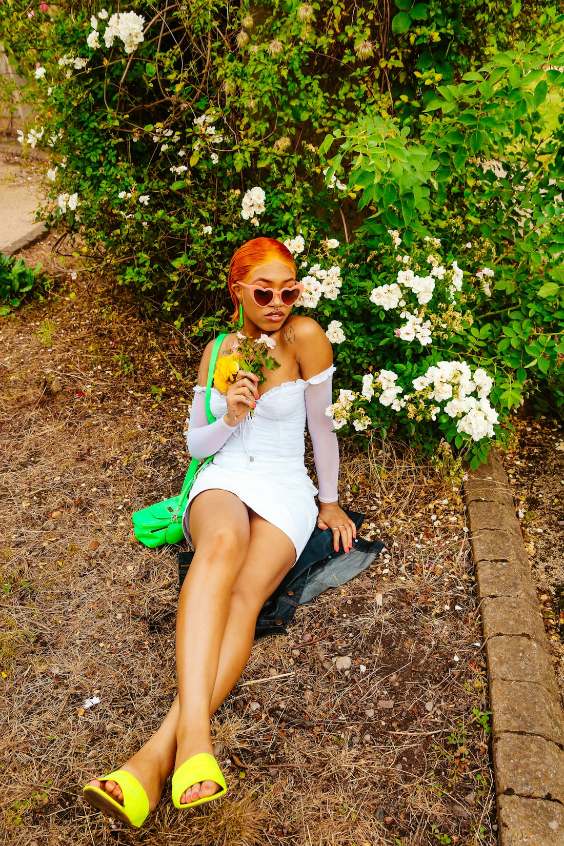 woman in white tank top sitting on green grass field