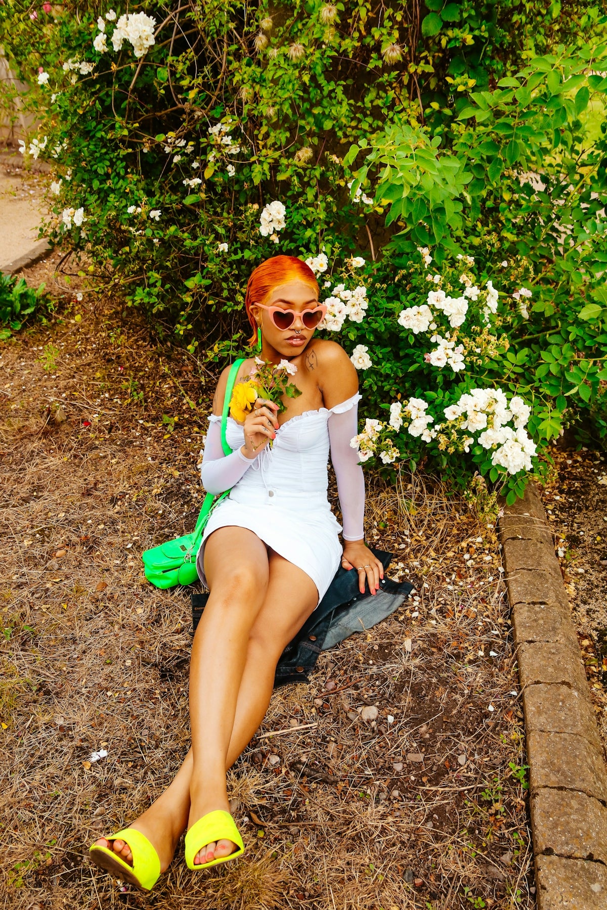 woman in white tank top sitting on green grass field