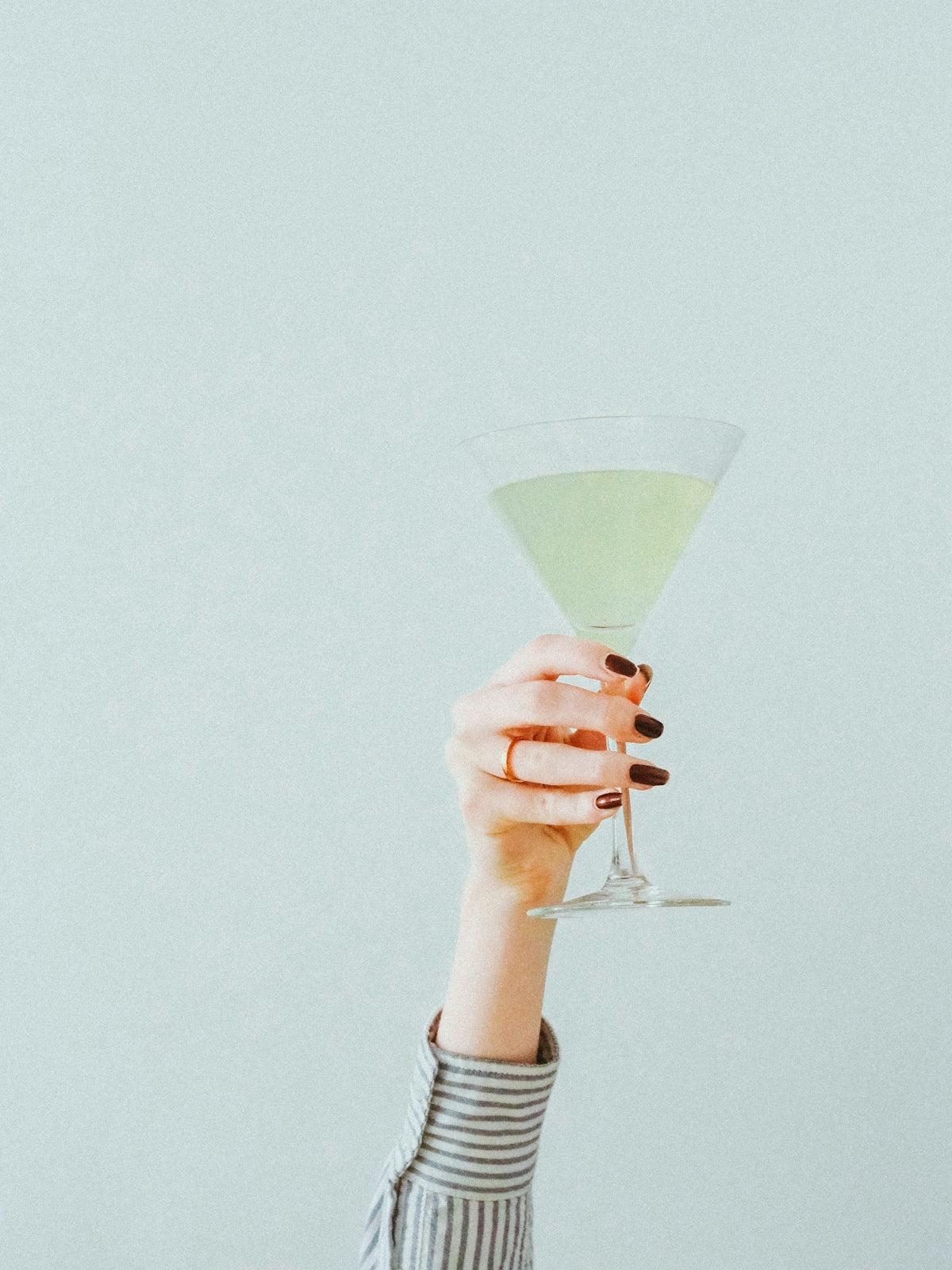 person holding clear cocktail glass