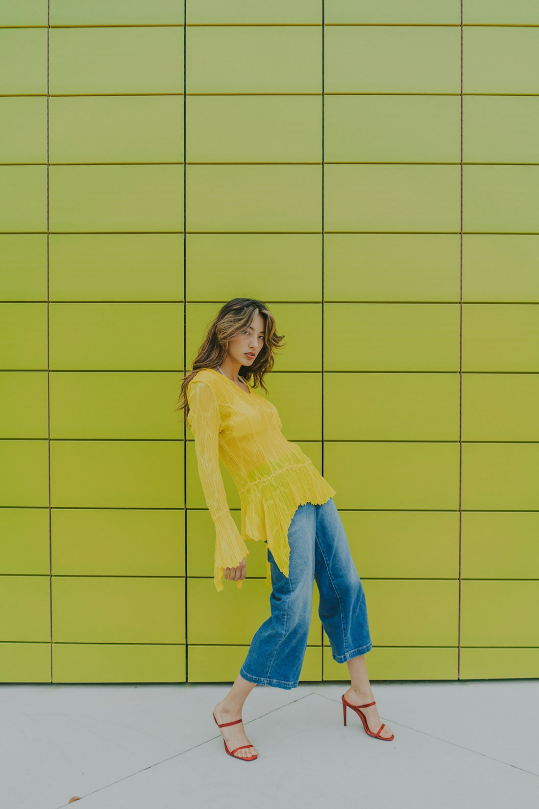 a woman standing in front of a green wall