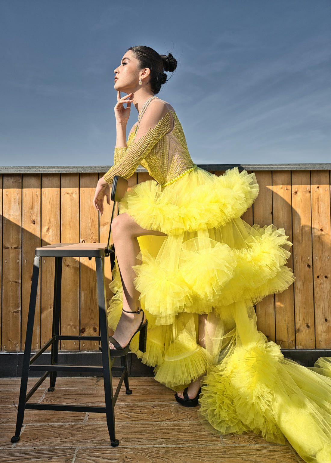 a woman in a yellow dress sitting on a chair