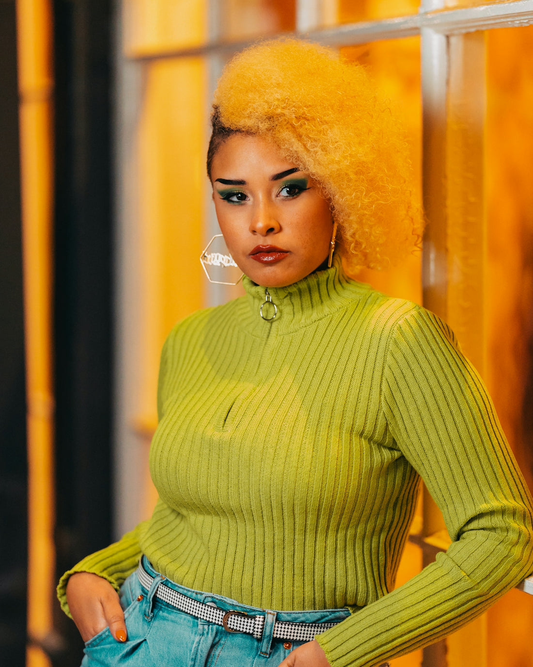 a woman with bright yellow hair is posing for a picture