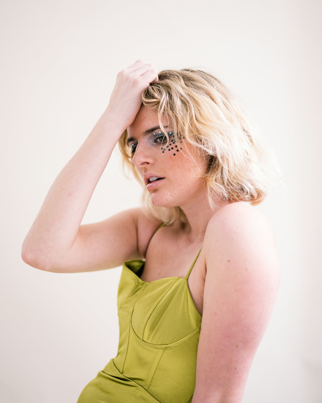 a woman in a green dress holding her hair