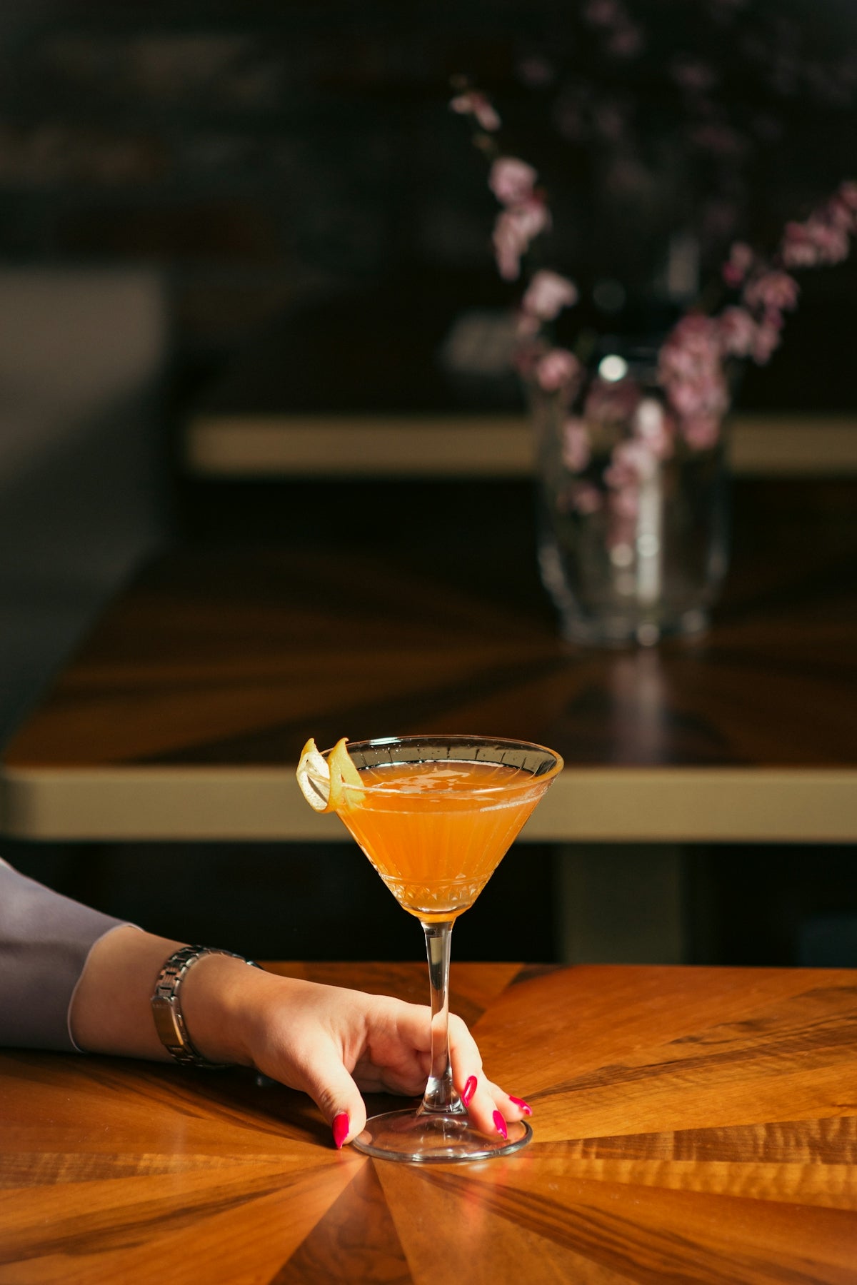 a woman's hand holding a glass of orange juice