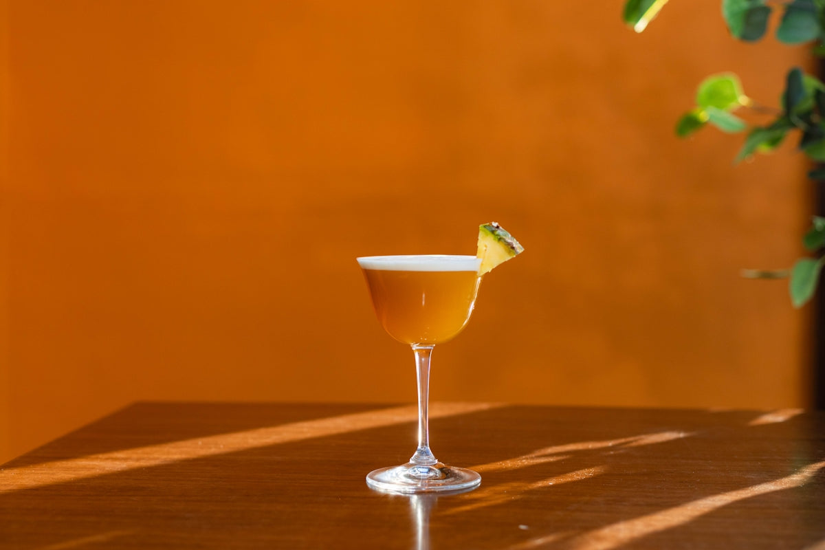 A glass of alcohol sitting on top of a table