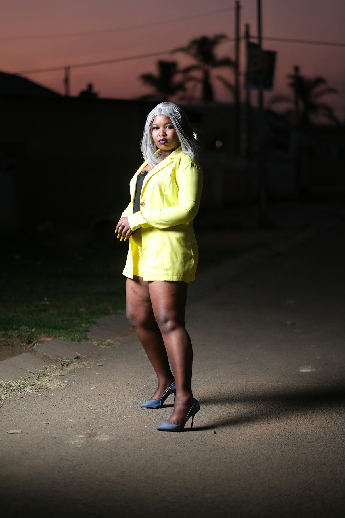 A woman in a yellow dress standing on a street