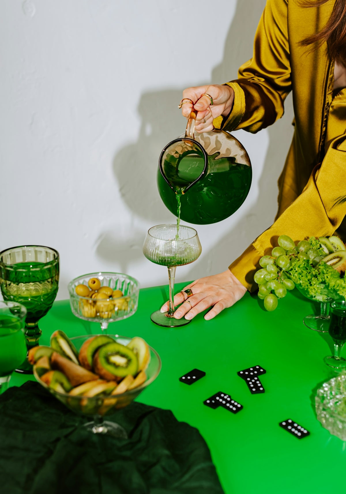 A woman pouring green liquid into a glass