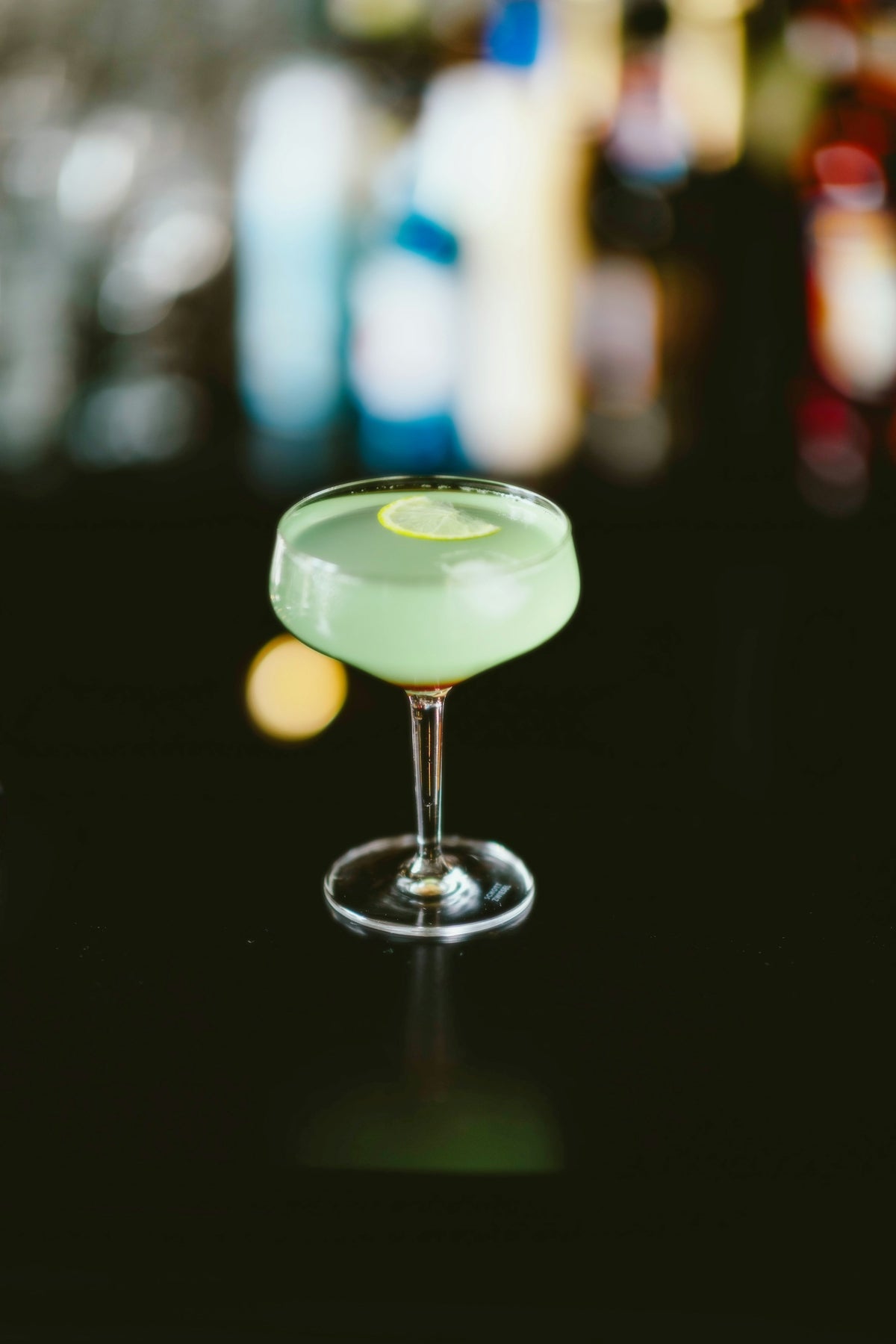 A green drink sitting on top of a table