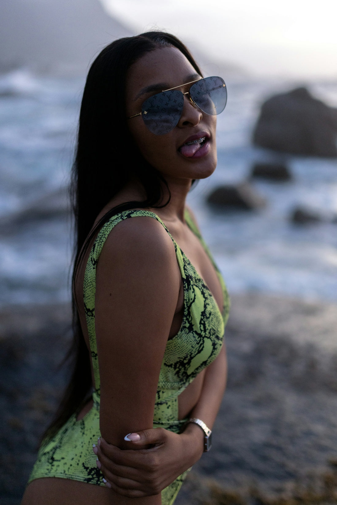 A woman in a yellow swimsuit standing on the beach