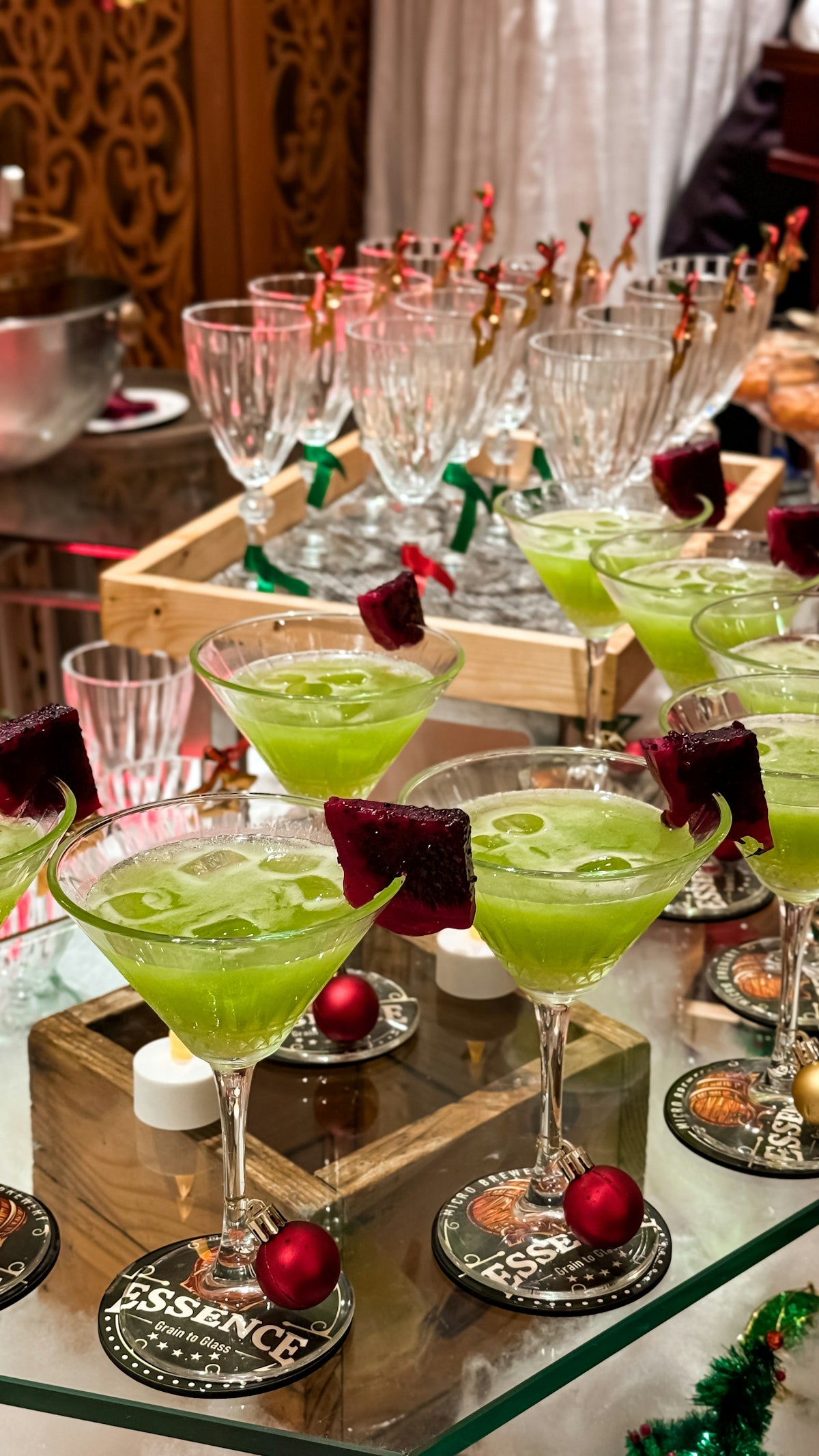 A table topped with lots of glasses filled with green liquid