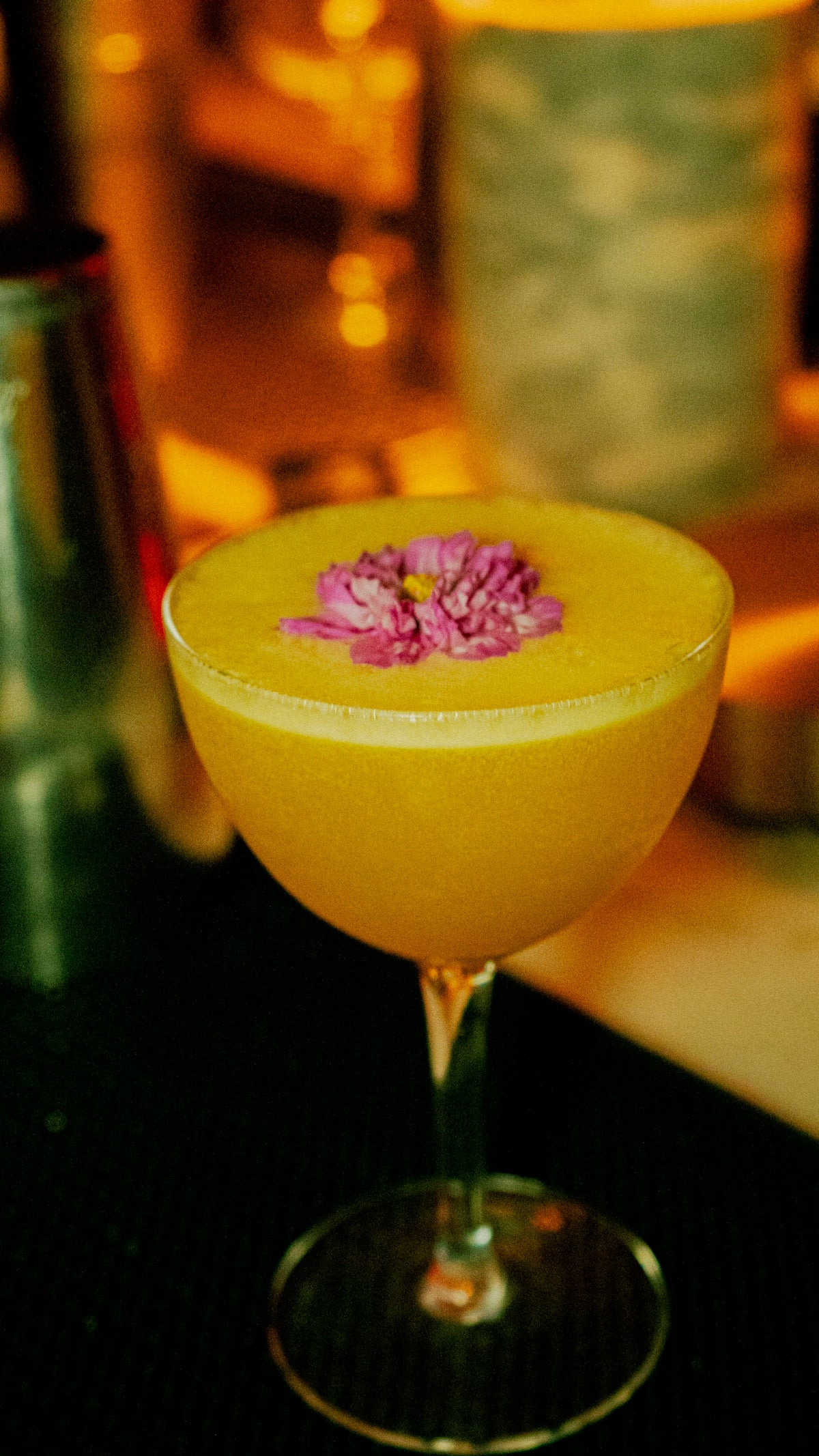 A cocktail with a flower garnish.