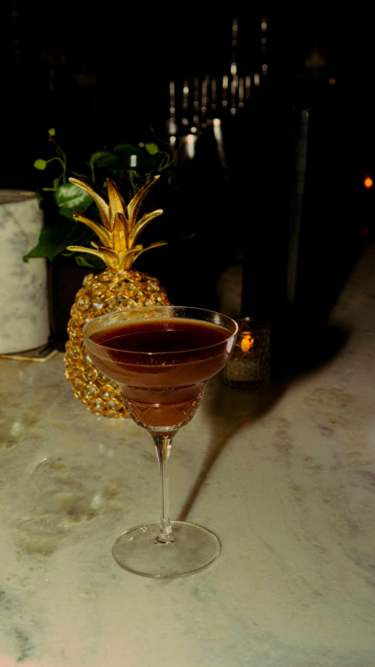 A cocktail sits on a marble bar.