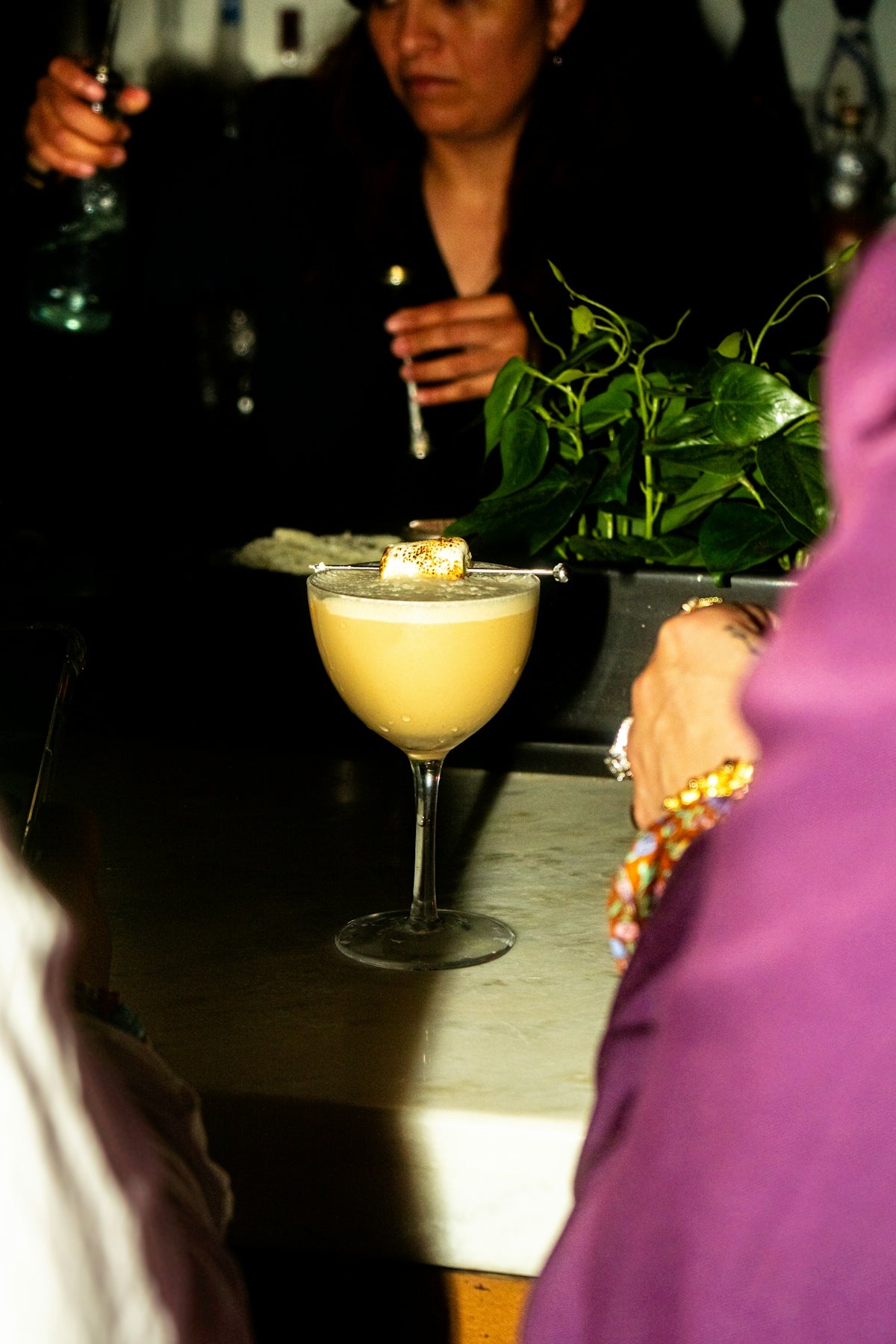 A cocktail is on a bar with people.