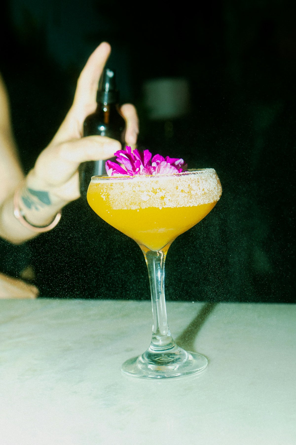 A cocktail is being sprayed with aromatic essence.