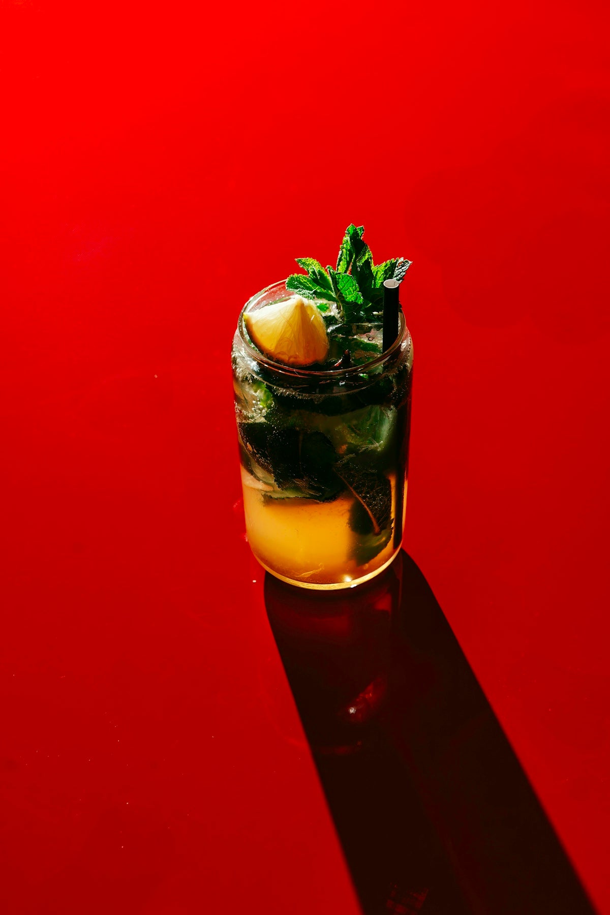A refreshing cocktail on a vibrant red surface.