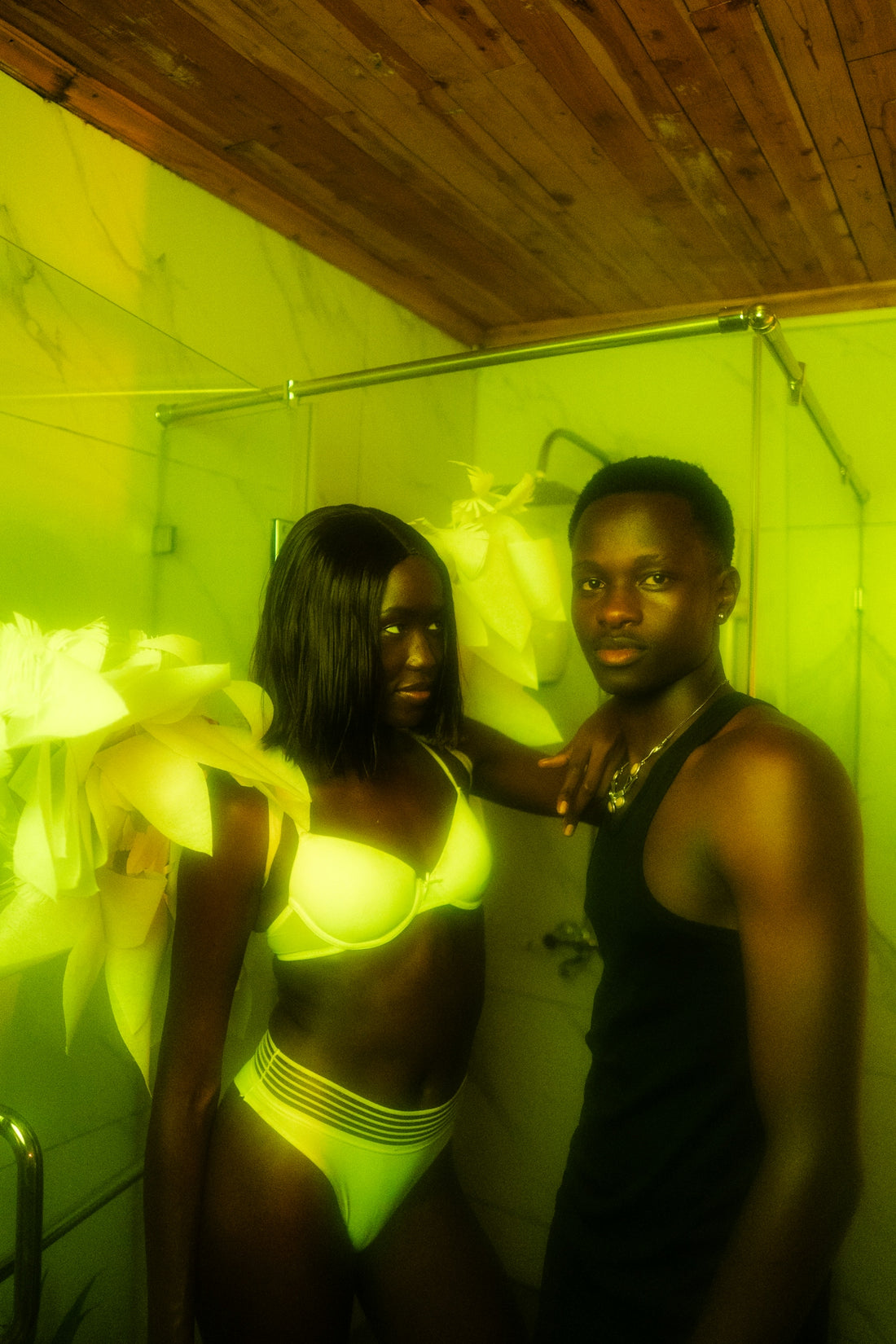 A couple poses in a brightly lit room.